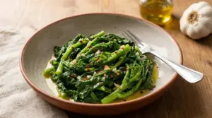 Piatto di cime di rapa condite con olio, aglio e peperoncino, servite in una ciotola con forchetta